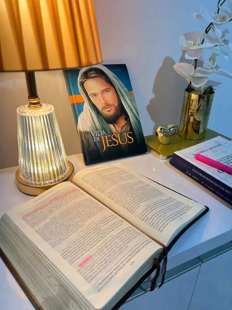 Bíblia aberta, livro Vida de Jesus e luminária acesa